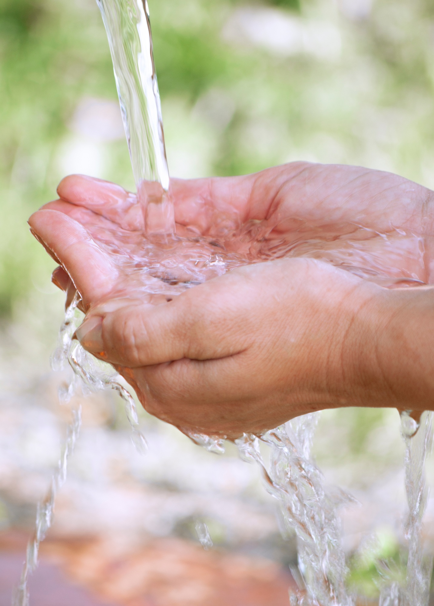 under the jet of clean water, a person washes his hands